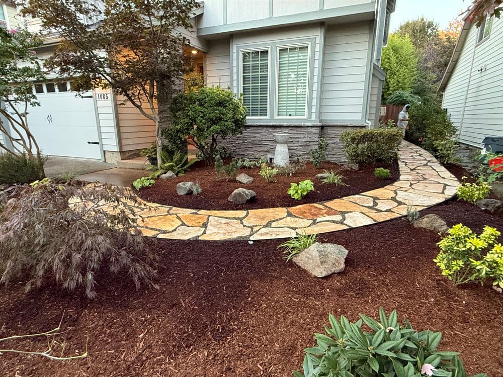 Pathway with stone tiles and landscaped garden at a modern home entrance.
