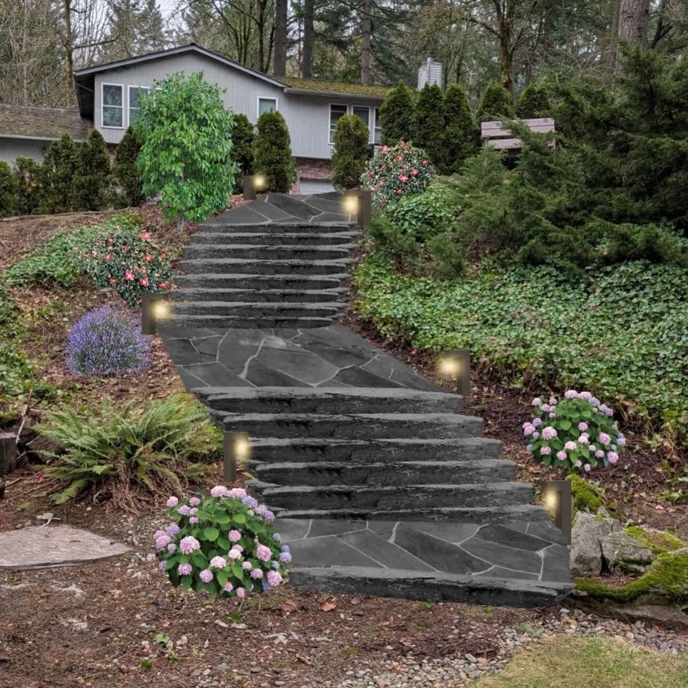 Elegant curved stone staircase with garden lights, surrounded by lush greenery and flowers.